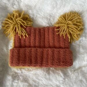 Orange and yellow child sized double pom toboggan.
